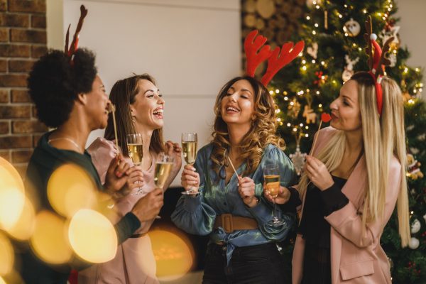Four Multietnic Female Friends Having Fun And Make Toast As They Celebrate At Home Christmas Party